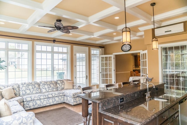 interior space with french doors, a wall mounted AC, coffered ceiling, and sink