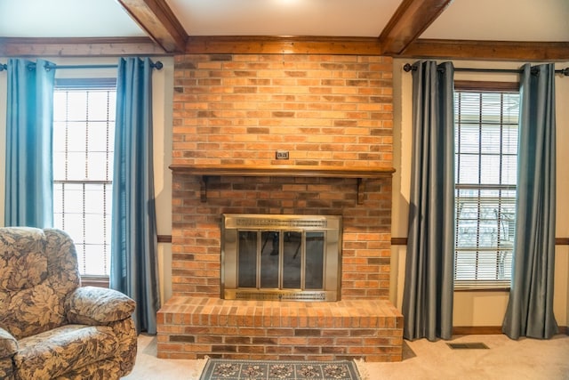 carpeted living room featuring beam ceiling and a fireplace