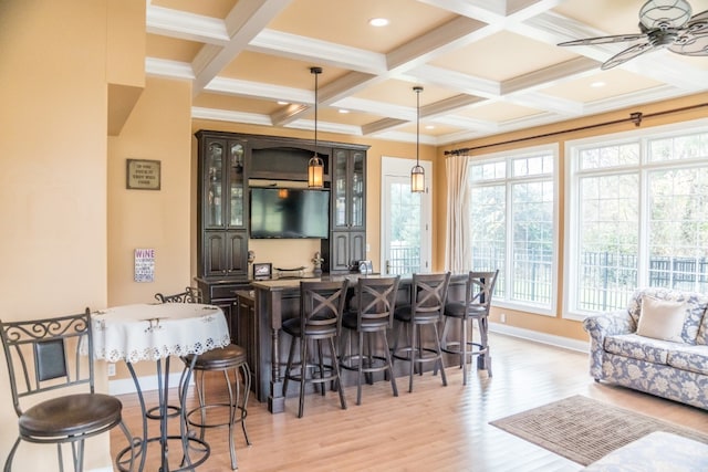 bar with ceiling fan, beamed ceiling, pendant lighting, light hardwood / wood-style floors, and dark brown cabinets