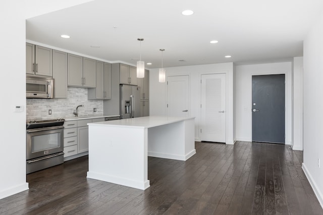 kitchen with a kitchen island, sink, stainless steel appliances, and dark wood-type flooring