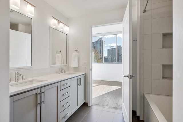 bathroom with dual vanity, shower / bathing tub combination, and tile floors