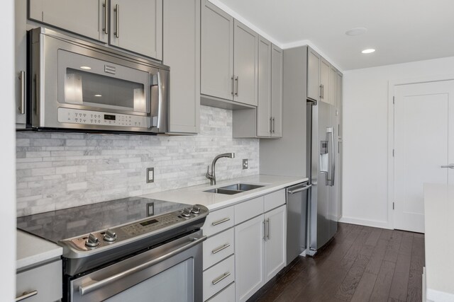 kitchen featuring tasteful backsplash, dark wood-type flooring, stainless steel appliances, and sink