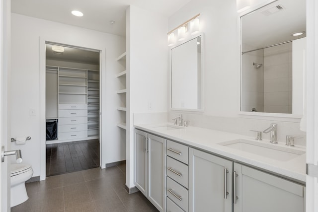 bathroom with dual vanity, toilet, and tile floors