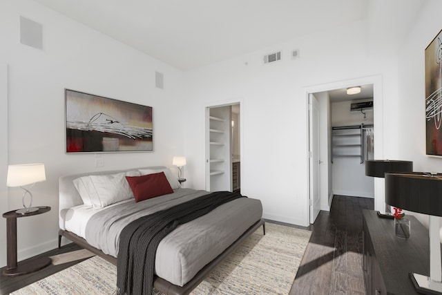 bedroom with dark wood-type flooring, a closet, and a walk in closet