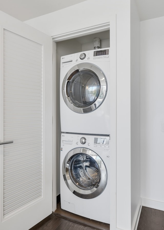 clothes washing area featuring stacked washer and dryer and dark hardwood / wood-style floors