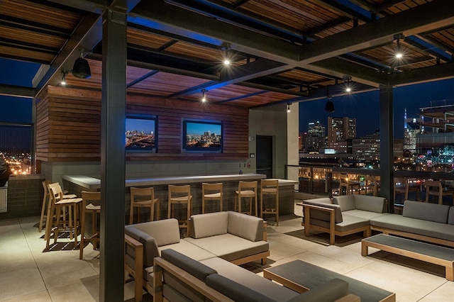 patio terrace at twilight with exterior bar and an outdoor living space