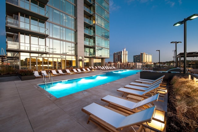 pool at dusk with a patio