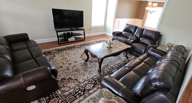 living room featuring a healthy amount of sunlight, hardwood / wood-style flooring, and a chandelier