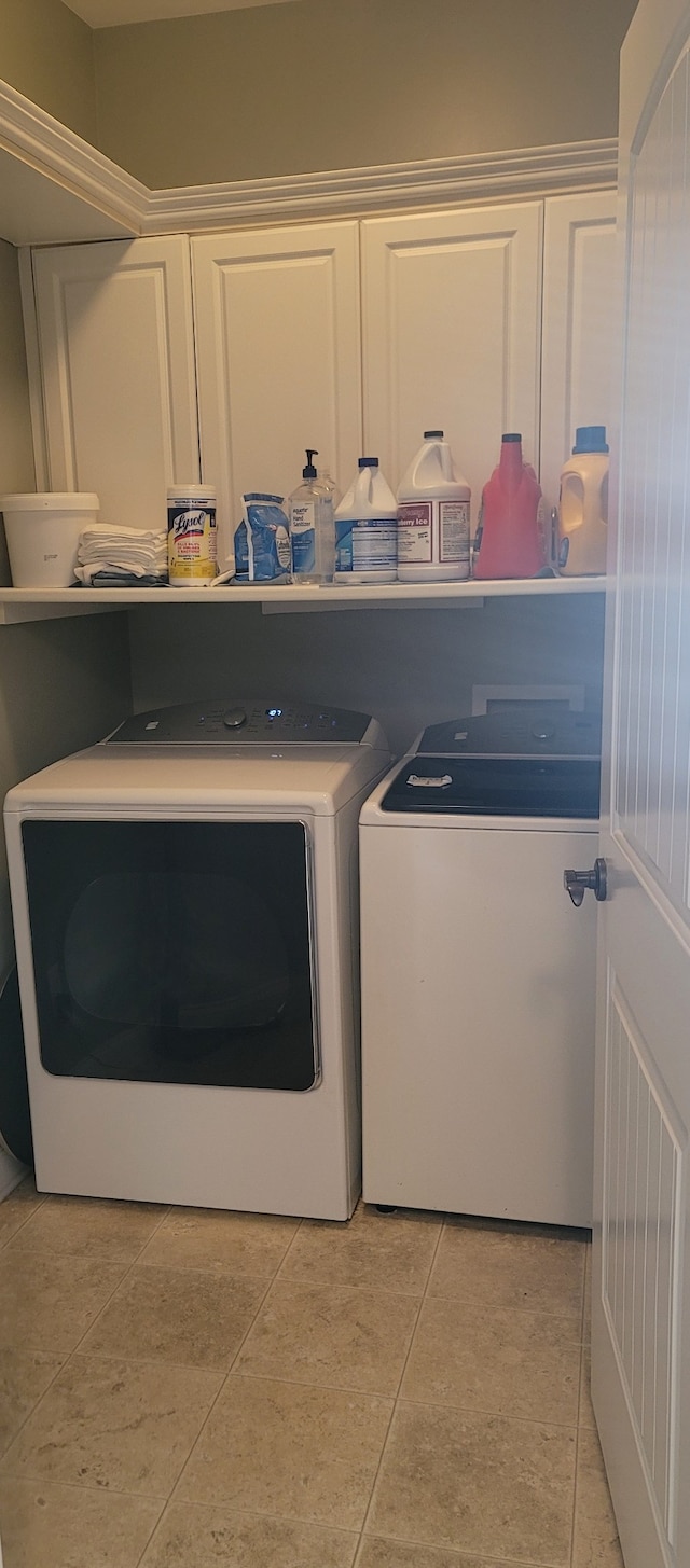 laundry room featuring cabinets, washer and dryer, and light tile floors