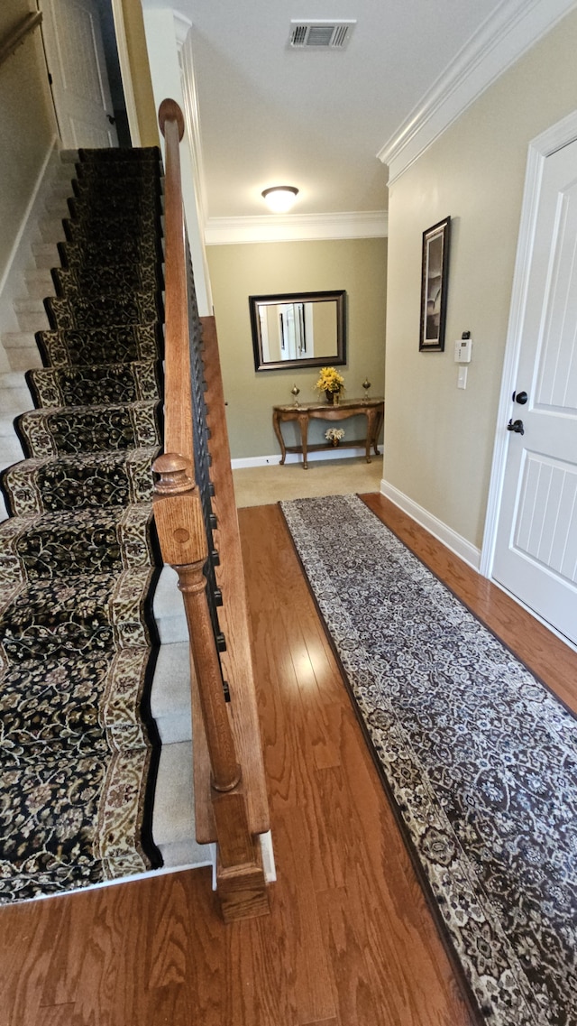 hallway with crown molding and hardwood / wood-style flooring