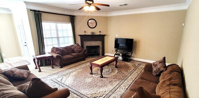 living room with ornamental molding, a tile fireplace, and ceiling fan