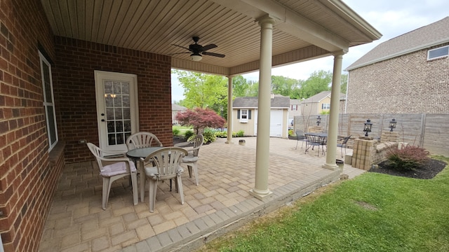 view of terrace with ceiling fan and a storage shed