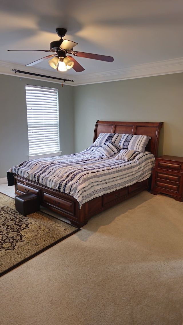 carpeted bedroom featuring ceiling fan and crown molding