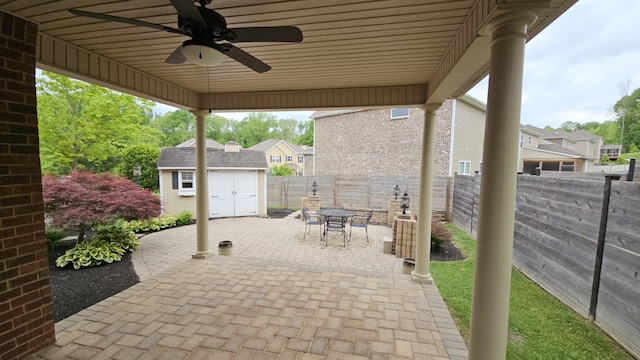 view of patio featuring ceiling fan and a storage unit