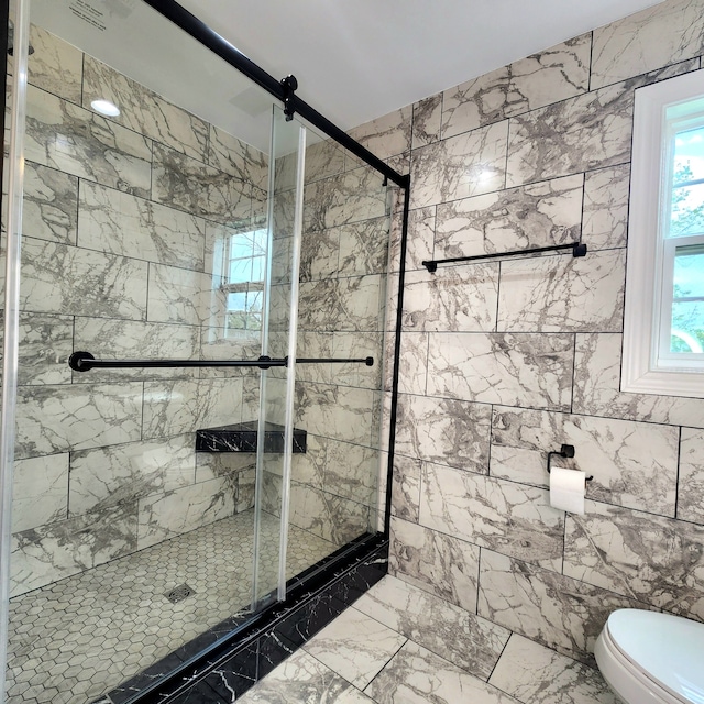 bathroom featuring tile flooring, an enclosed shower, toilet, and a wealth of natural light