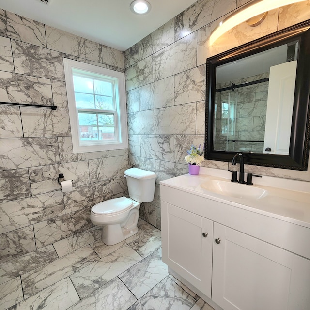 bathroom featuring tile walls, oversized vanity, toilet, and tile flooring