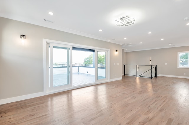 spare room with crown molding and light wood-type flooring