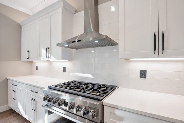 kitchen featuring white cabinetry, hardwood / wood-style floors, wall chimney range hood, tasteful backsplash, and high end range