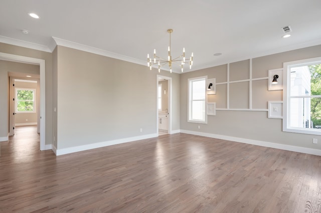 unfurnished room with hardwood / wood-style flooring, a chandelier, and ornamental molding