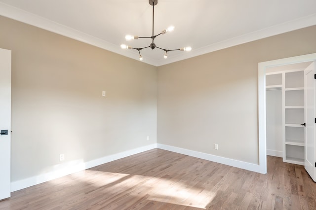 interior space with a closet, crown molding, light wood-type flooring, and a chandelier