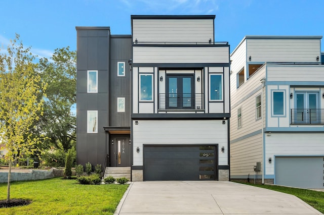 contemporary home with a balcony, a garage, and a front yard