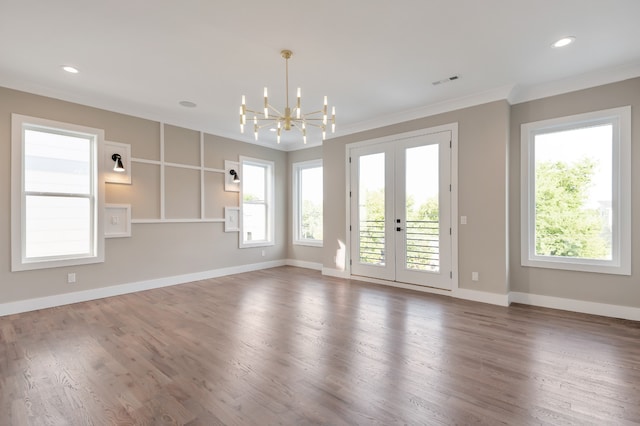 empty room featuring french doors, dark hardwood / wood-style flooring, a notable chandelier, and ornamental molding