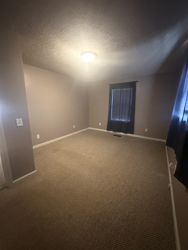 carpeted empty room with a textured ceiling