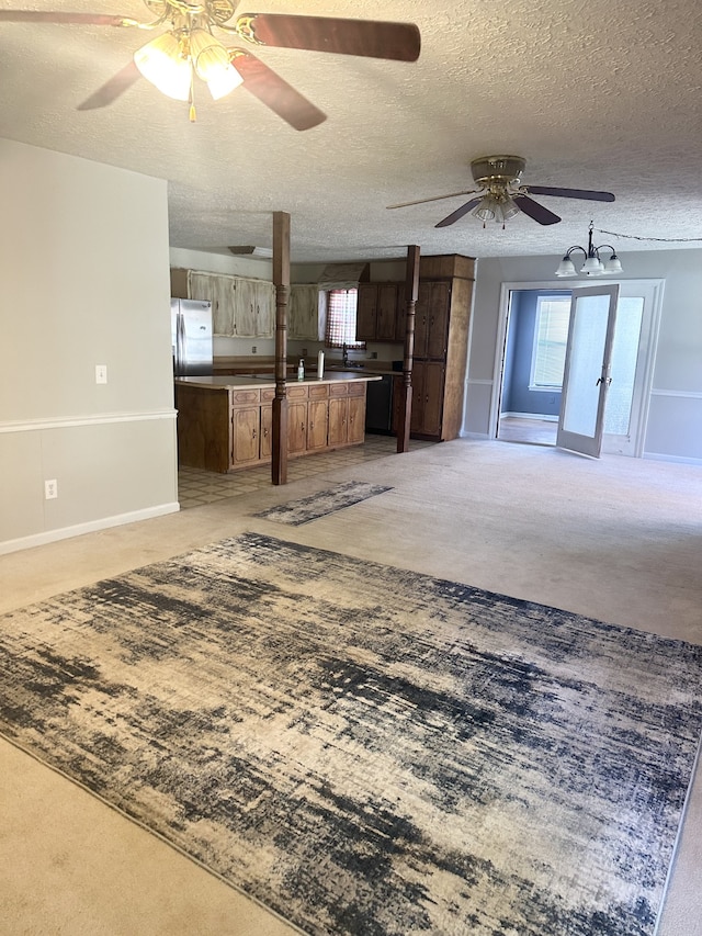 unfurnished living room with french doors, light carpet, a textured ceiling, and ceiling fan