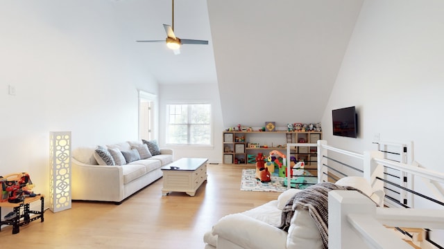 living room with high vaulted ceiling, light hardwood / wood-style flooring, ceiling fan, and a fireplace