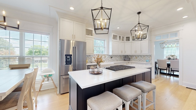 kitchen with hanging light fixtures, tasteful backsplash, light wood-type flooring, and a kitchen island