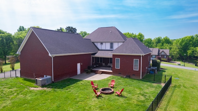 rear view of property featuring a patio, an outdoor fire pit, and a lawn