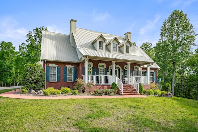 cape cod house with covered porch and a front yard