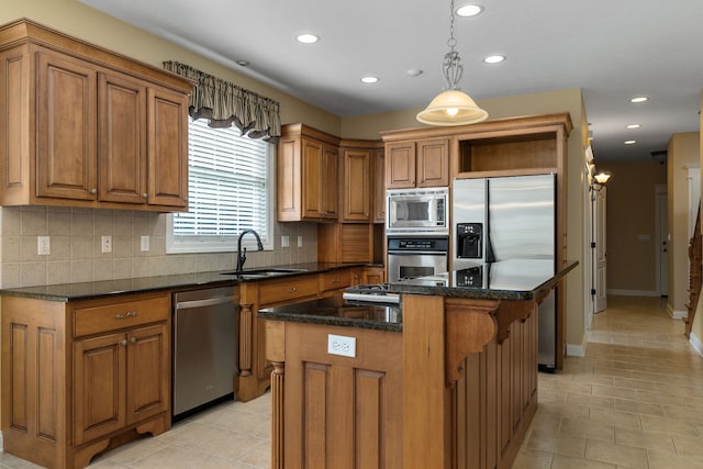 kitchen with tasteful backsplash, a kitchen island, appliances with stainless steel finishes, pendant lighting, and sink