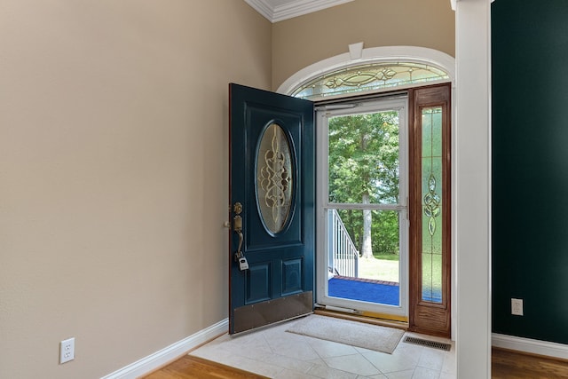 entryway with crown molding and hardwood / wood-style floors