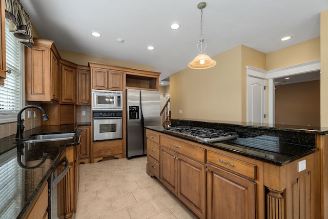 kitchen with decorative light fixtures, sink, dark stone countertops, appliances with stainless steel finishes, and light tile patterned floors