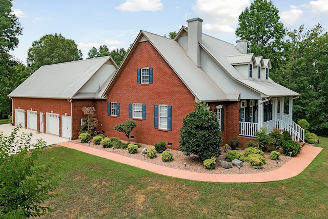 view of front of property featuring covered porch, a garage, and a front yard