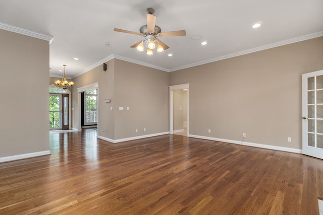 spare room featuring hardwood / wood-style flooring, ceiling fan with notable chandelier, and crown molding