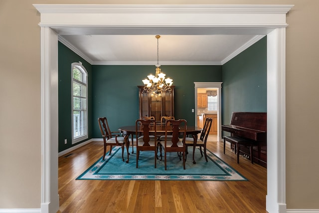 dining area featuring a notable chandelier, crown molding, and hardwood / wood-style floors