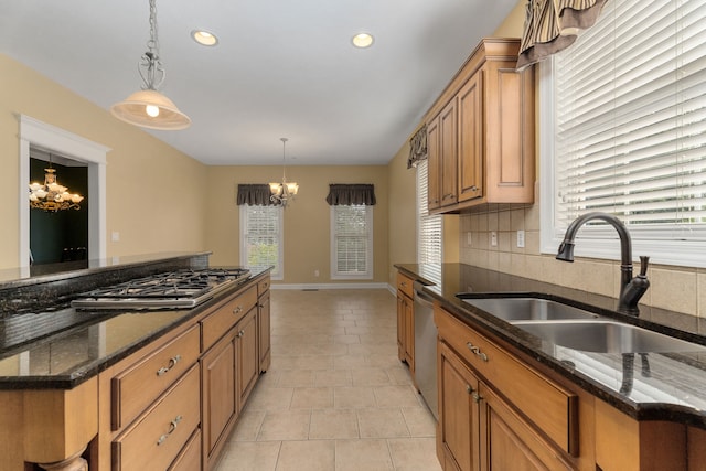 kitchen with sink, decorative light fixtures, light tile patterned floors, and dark stone counters