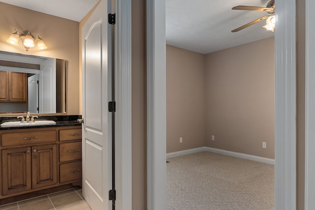 bathroom with tile patterned flooring, vanity, and ceiling fan