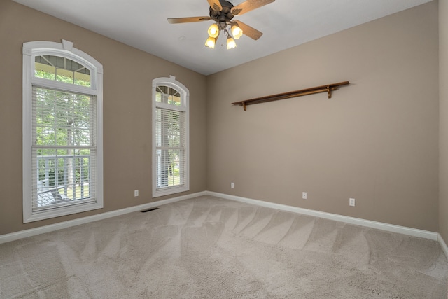 carpeted spare room featuring ceiling fan