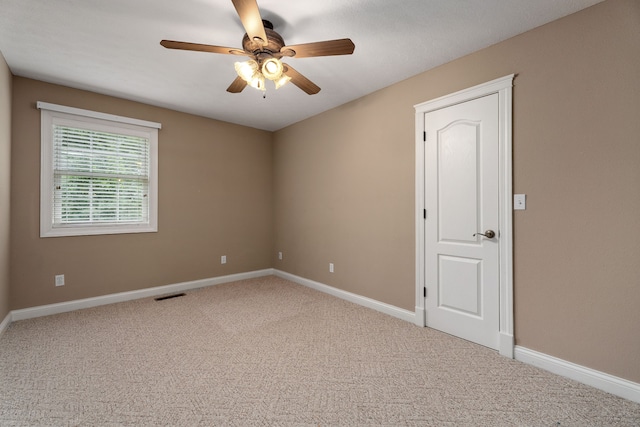 carpeted spare room with ceiling fan