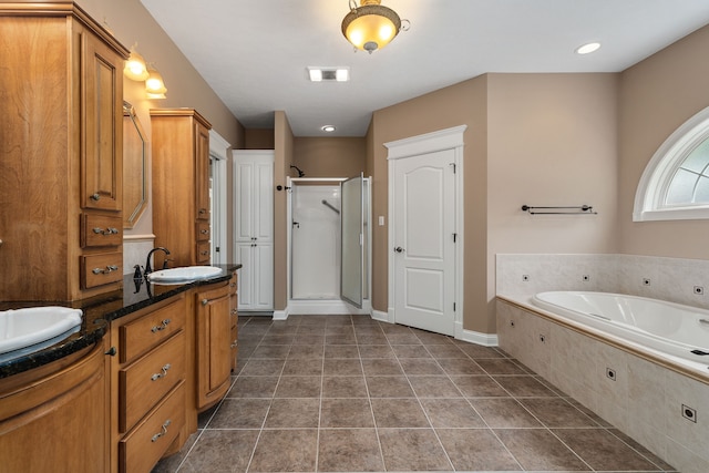 bathroom featuring tile patterned flooring, separate shower and tub, and dual bowl vanity