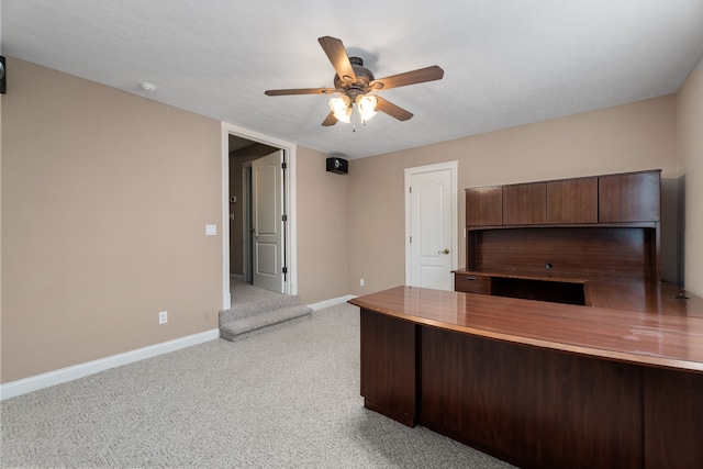 unfurnished office with ceiling fan and light colored carpet