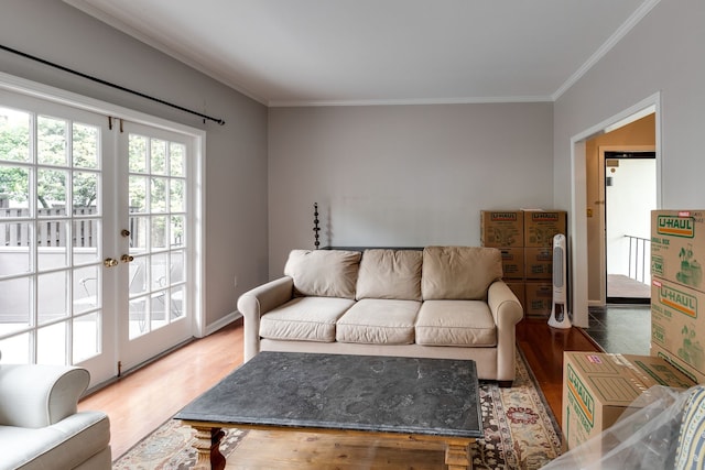 living room with hardwood / wood-style floors, ornamental molding, and french doors