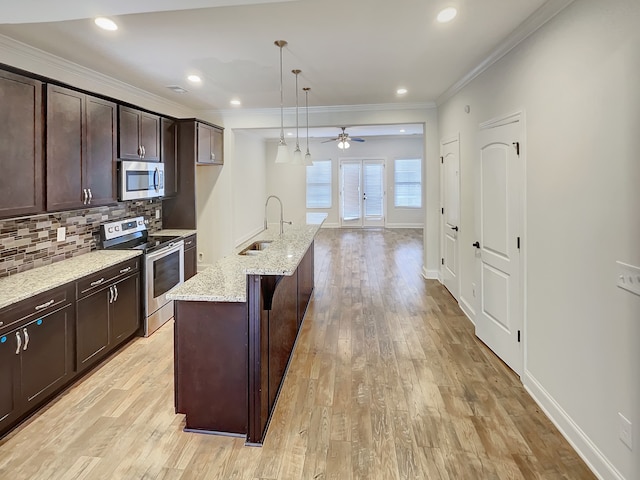 kitchen with decorative light fixtures, appliances with stainless steel finishes, light hardwood / wood-style flooring, ceiling fan, and sink