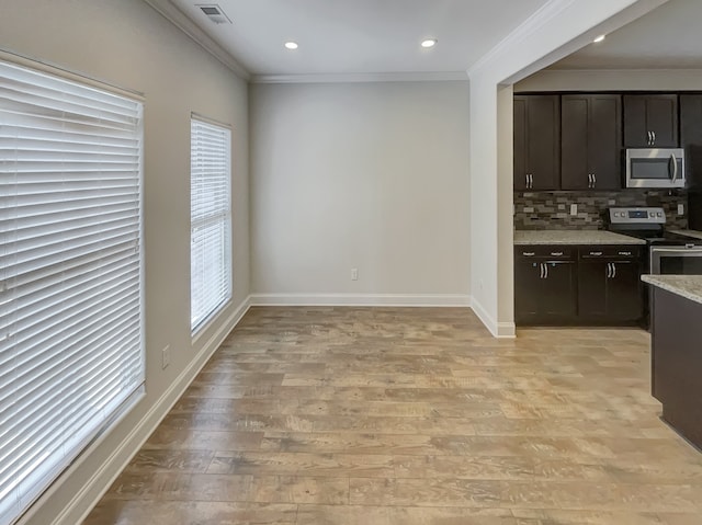 kitchen with tasteful backsplash, dark brown cabinets, stainless steel appliances, and light wood-type flooring