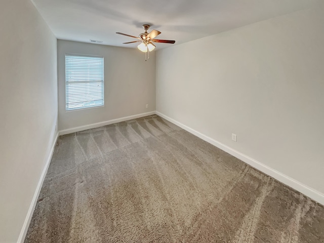 carpeted spare room featuring ceiling fan