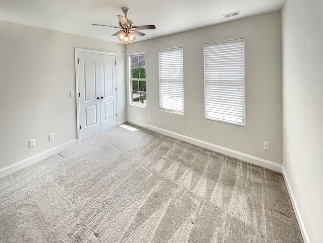 spare room featuring carpet and ceiling fan