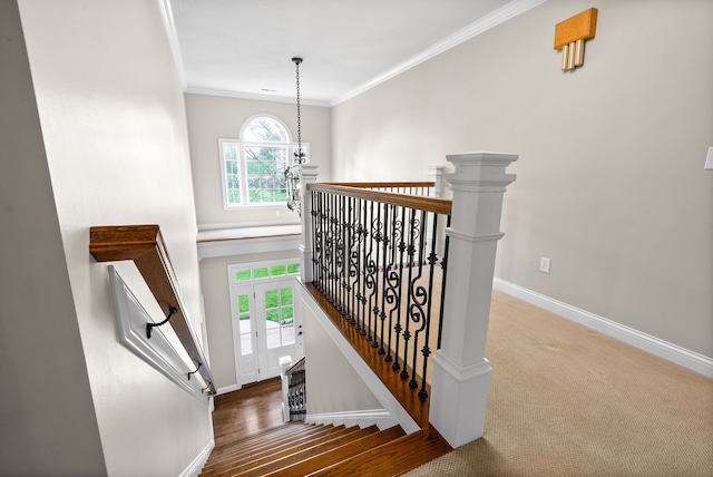 stairs with carpet, a chandelier, and crown molding